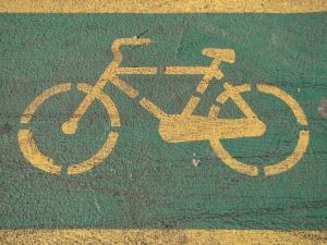 Image of a yellow bicycle symbol painted on a green background