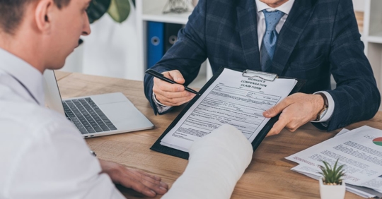 man in cast filing workers' compensation form
