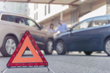 Car accident in background with warning sign in the foreground