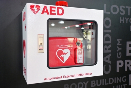 Automated external defibrillator in red box hang on wall in gym fitness. AED medical first aid device. It is portable electronic device that automatically diagnoses life-threatening cardiac arrest