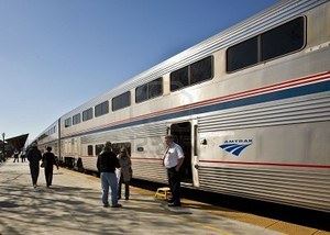 8075972-amtrak-conductor-and-passengers-on-a-sunny-platform.jpg