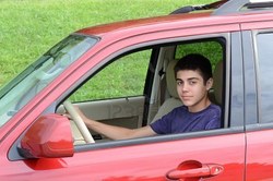 10469339-a-confident-newly-licensed-teenage-male-driver-sits-in-his-shiny-new-red-car-close-up-in-horizontal-.jpg